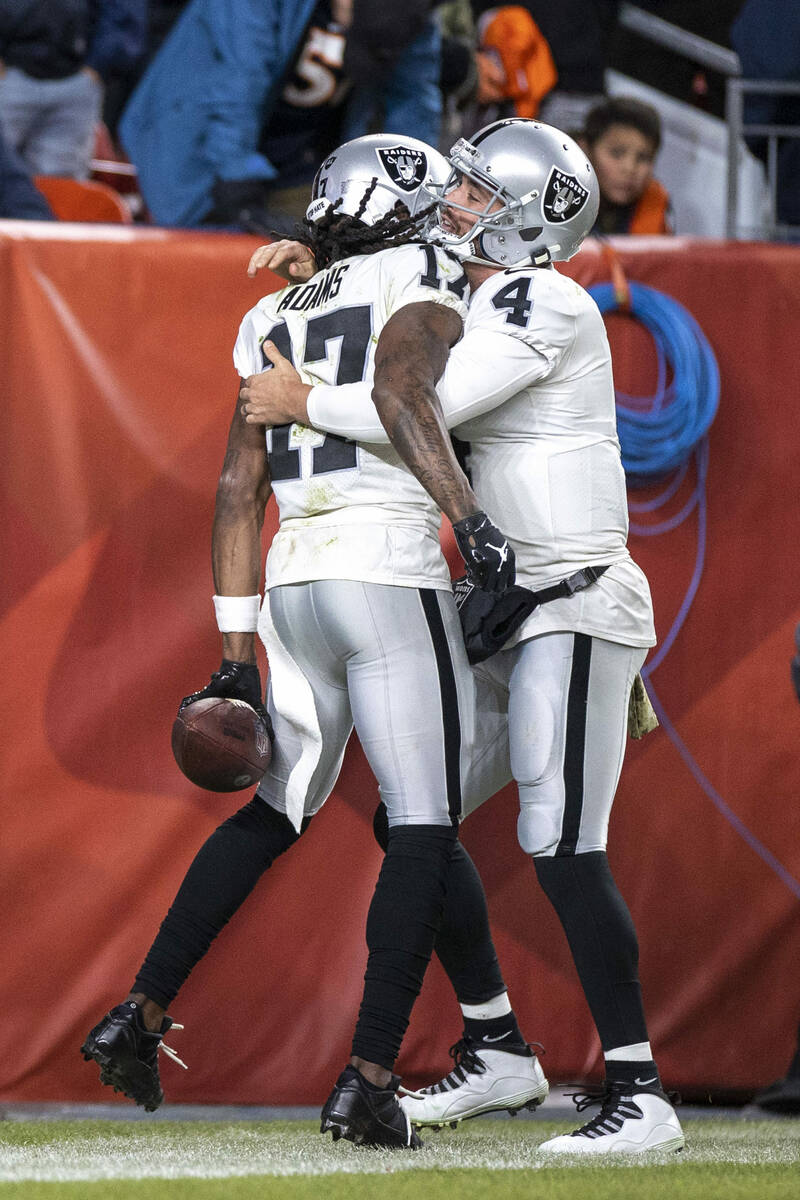 Raiders wide receiver Davante Adams (17) is congratulated by quarterback Derek Carr (4) after s ...