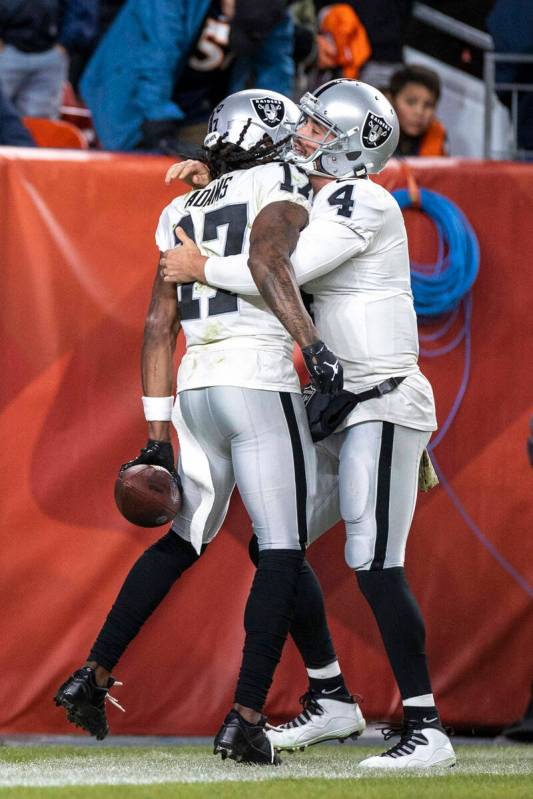 Raiders wide receiver Davante Adams (17) is congratulated by quarterback Derek Carr (4) after s ...