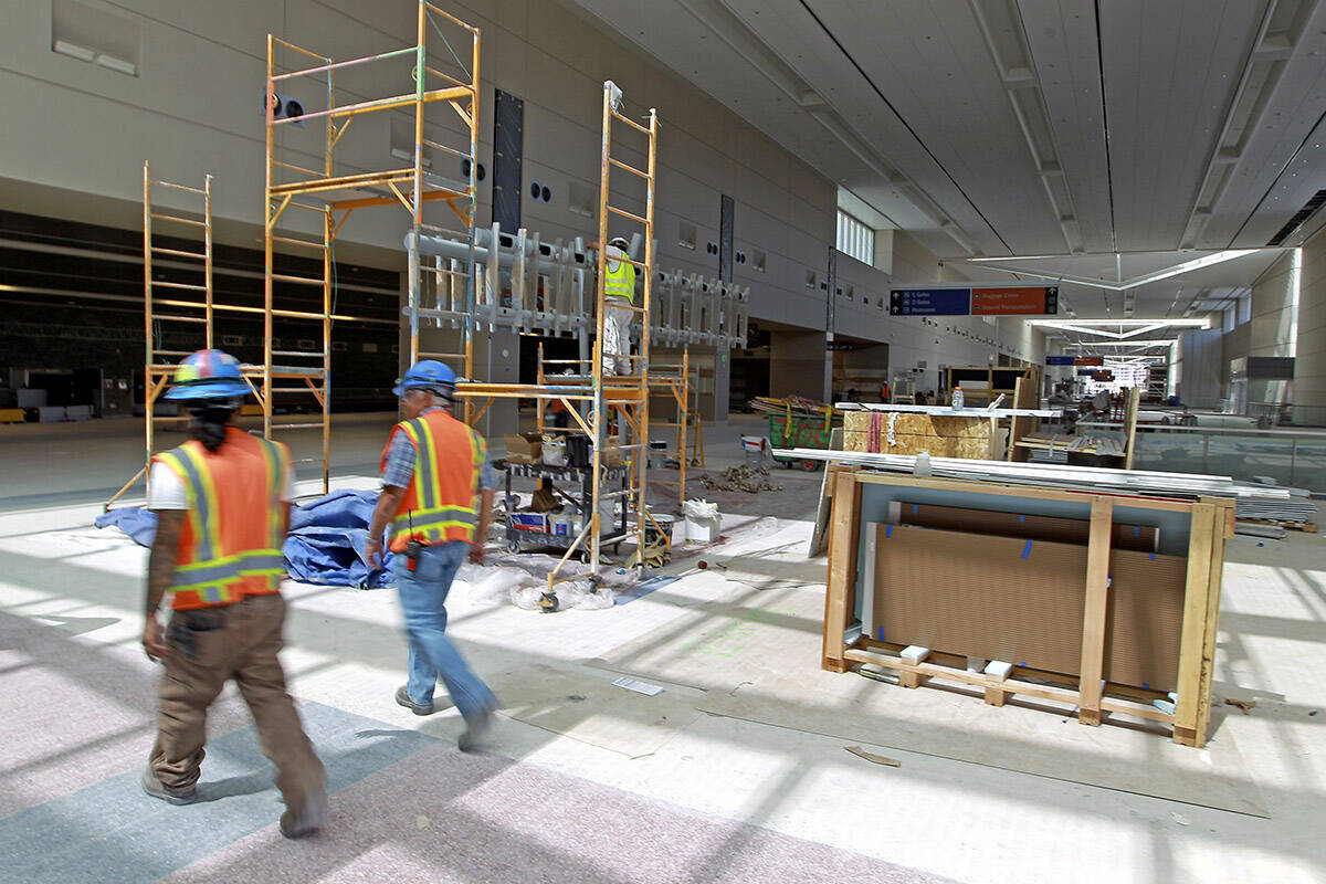 Construction workers walk through the new McCarran Terminal 3 on Wednesday, June 29, 2011. (Las ...