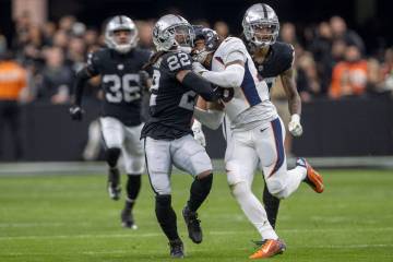 Raiders running back Ameer Abdullah (22) is tied up with Denver Broncos cornerback Art Green (2 ...