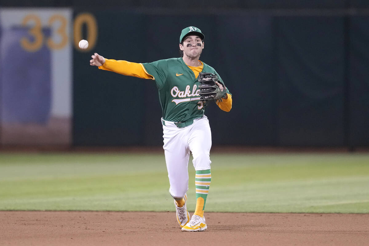 Oakland Athletics shortstop Jacob Wilson throws out Texas Rangers' Adolis García at first ...