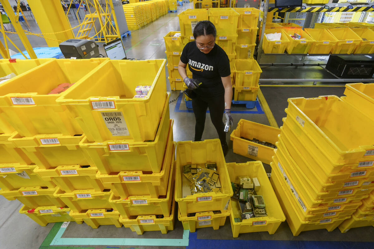 FILE - An employee scans incoming items at a receiving station at the Amazon OXR1 fulfillment c ...