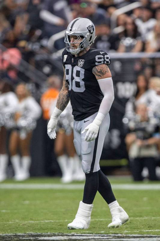 Raiders defensive end Maxx Crosby (98) wears a walking boot on his left ankle on the field duri ...