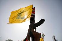 A Houthi supporter raises a Hezbollah flag during an anti-Israel and anti-U.S. rally in Sanaa, ...