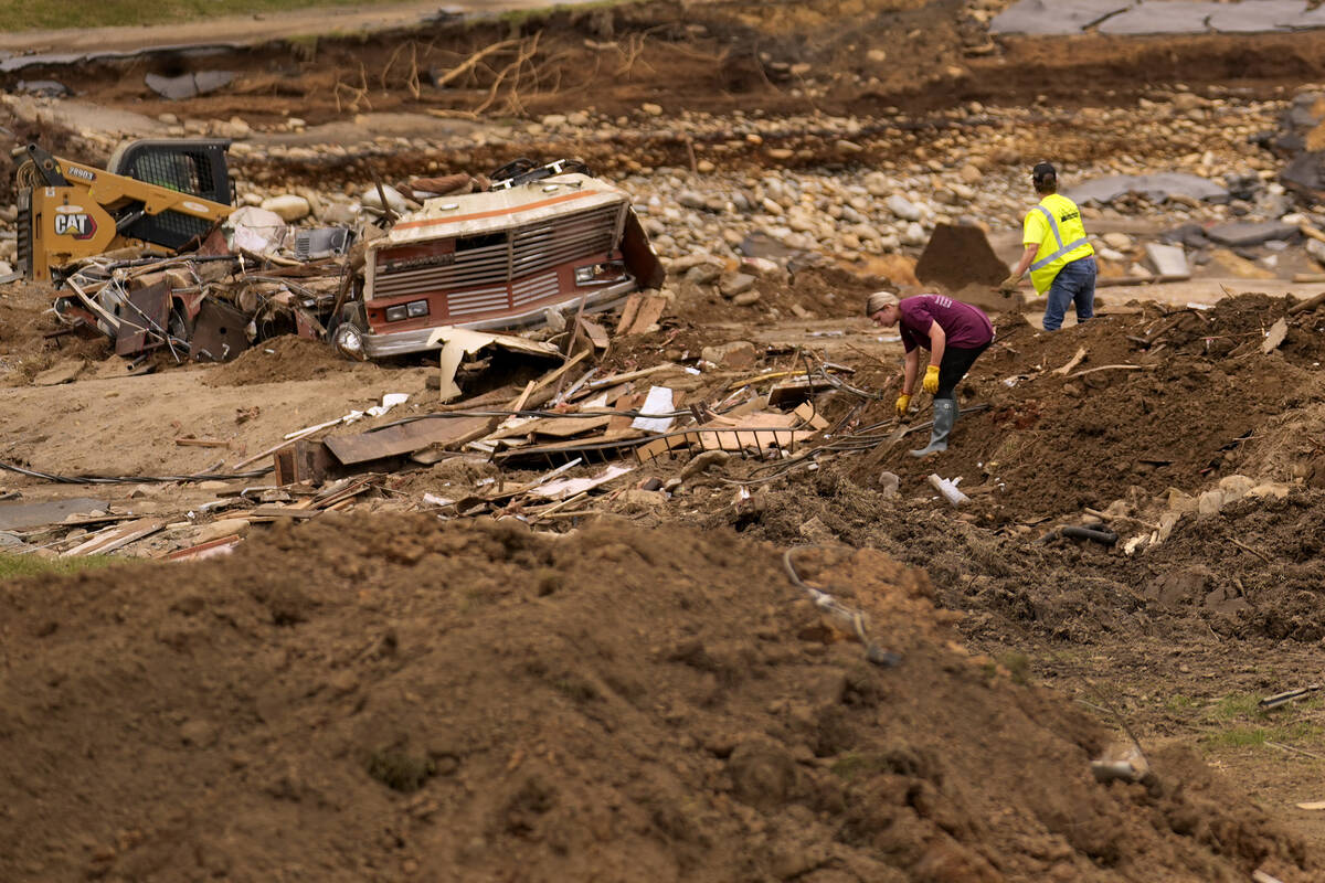 People clean up debris left in the aftermath of Hurricane Helene Friday, Oct. 4, 2024, in Erwin ...