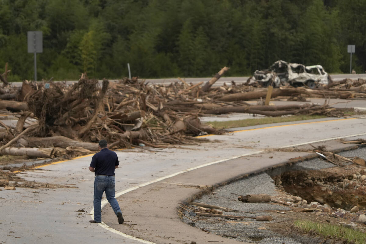 A person walks on Interstate 26 as debris covers the roadway in the aftermath of Hurricane Hele ...