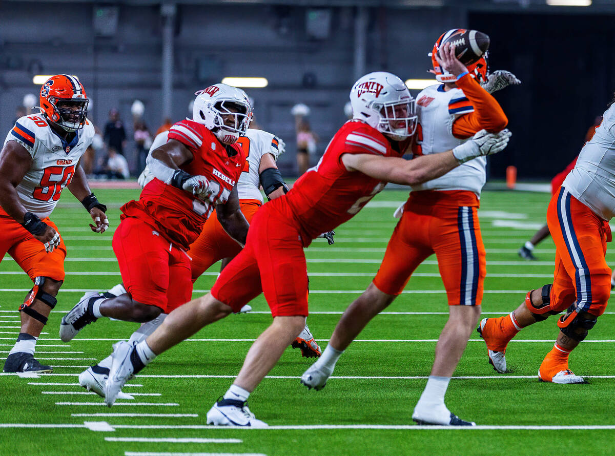 UNLV defensive lineman Fisher Camac (28) gets to Syracuse Orange quarterback Kyle McCord (6) to ...