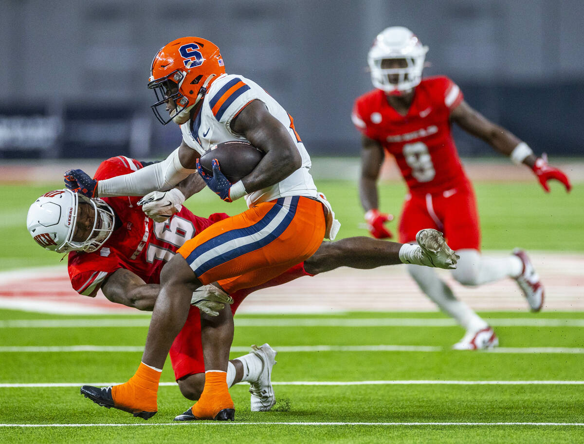 UNLV linebacker Mani Powell (16) hangs on for a tackle against Syracuse Orange running back LeQ ...