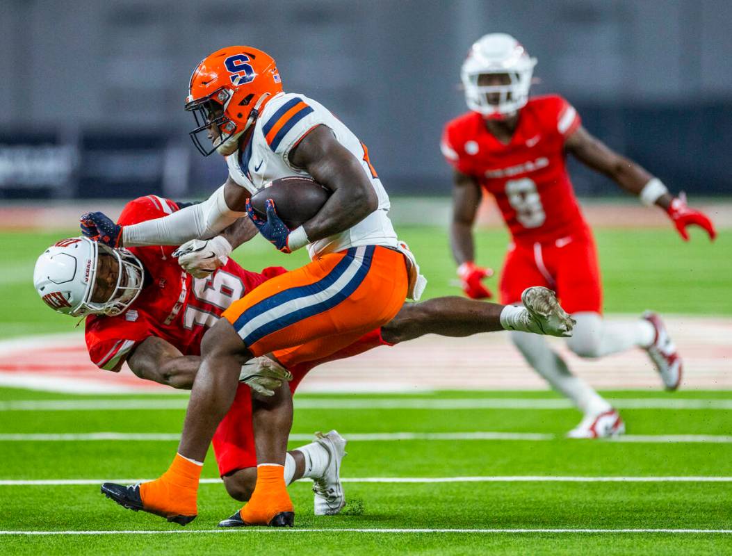 UNLV linebacker Mani Powell (16) hangs on for a tackle against Syracuse Orange running back LeQ ...