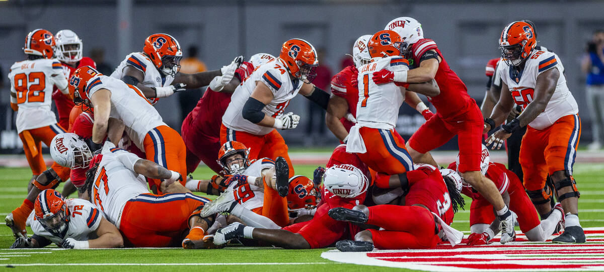 Syracuse Orange running back LeQuint Allen (1) is stood up amongst a pile of players by UNLV de ...