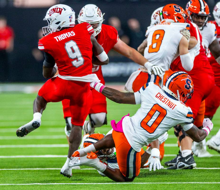 UNLV running back Jai'Den Thomas (9) spins out of a tackle attempt by Syracuse Orange defensive ...