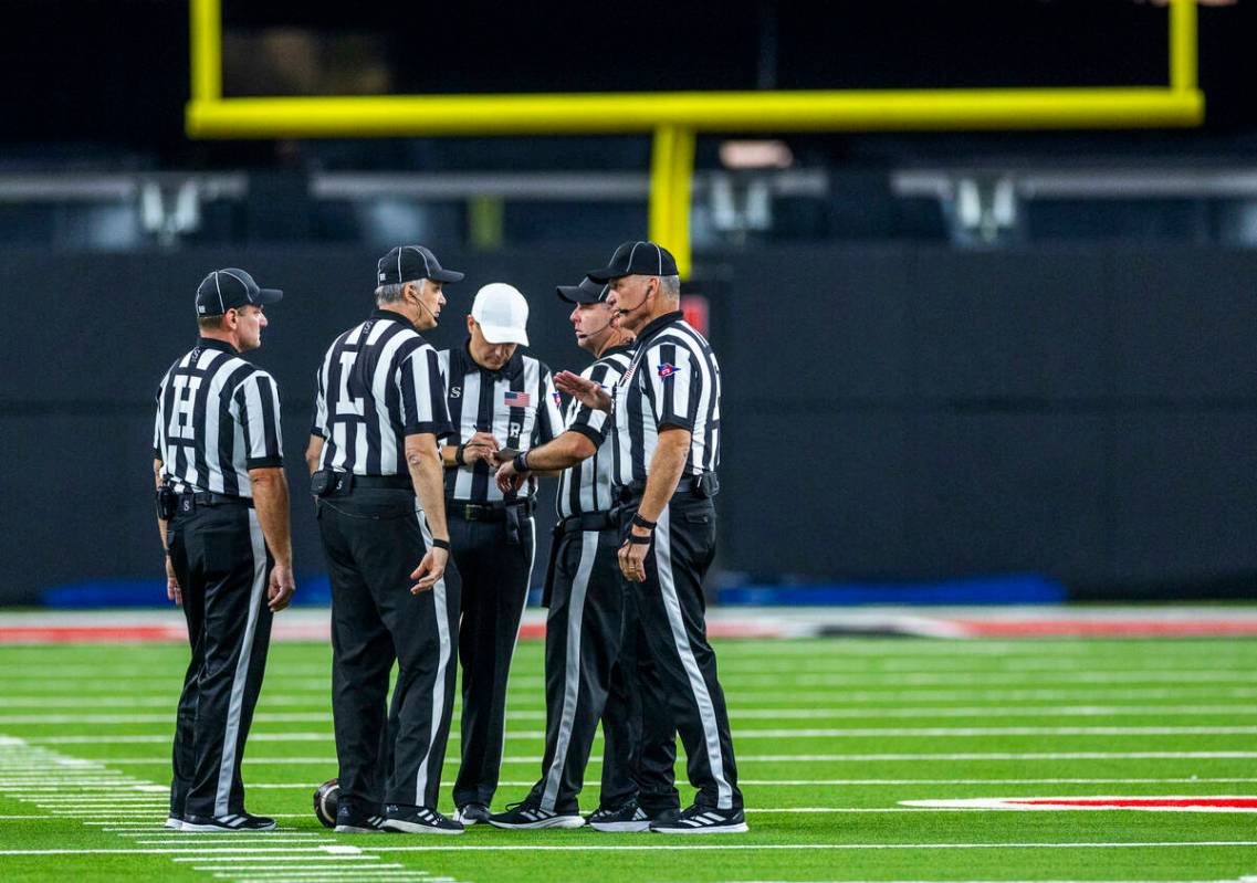 Officials confer on the field during a timeout with UNLV and the Syracuse Orange during the fir ...