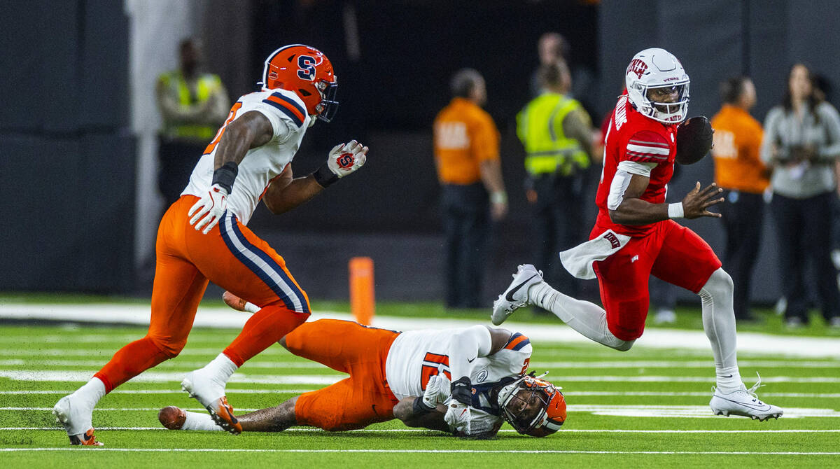 UNLV quarterback Hajj-Malik Williams (6) breaks a tackle attempt by Syracuse Orange linebacker ...