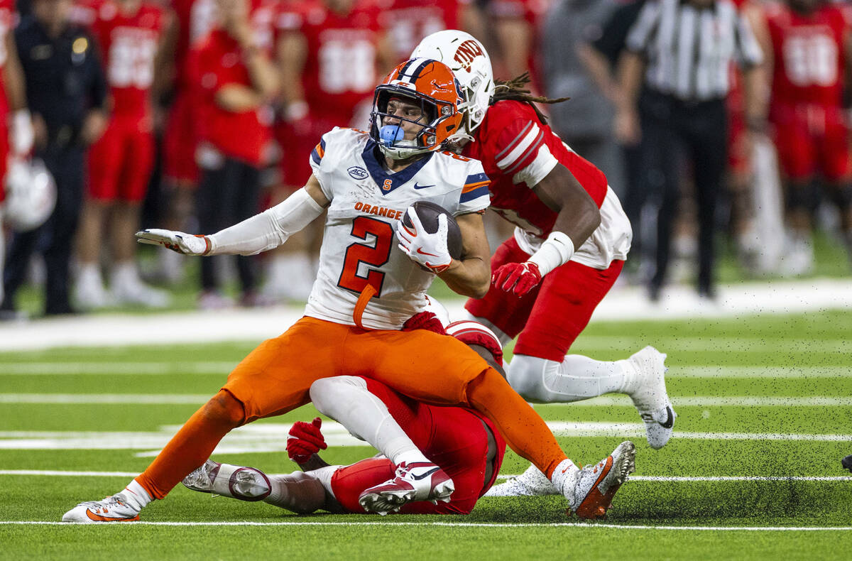 Syracuse Orange wide receiver Trebor Pena (2) is dragged to the turf from below by UNLV defensi ...