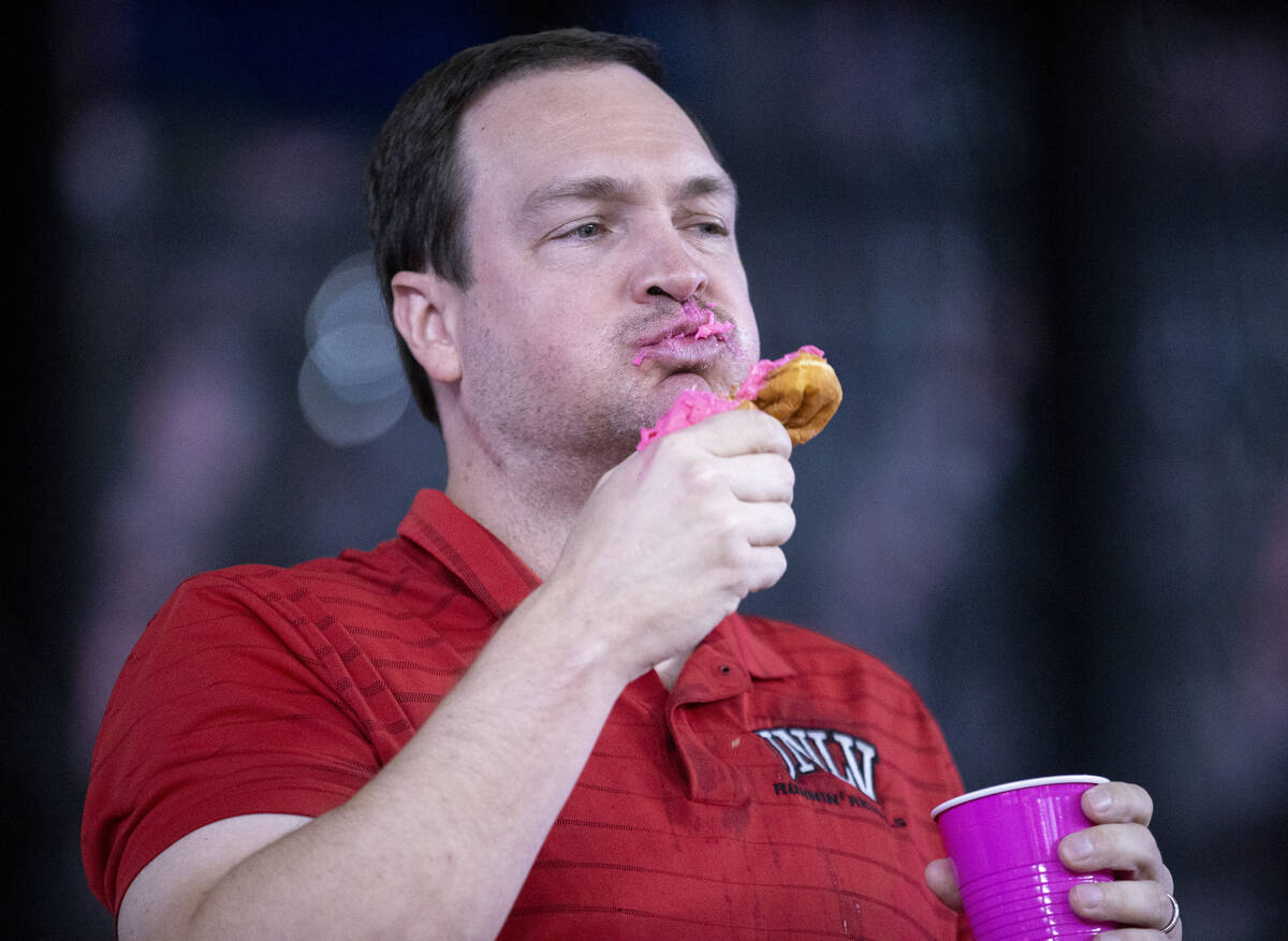 UNLV Basketball Head Coach Kevin Kruger competes in a doughnut eating contest for breast cancer ...