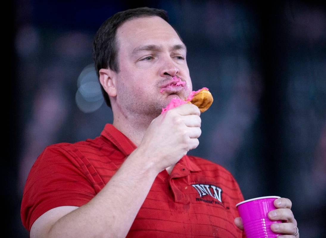 UNLV Basketball Head Coach Kevin Kruger competes in a doughnut eating contest for breast cancer ...