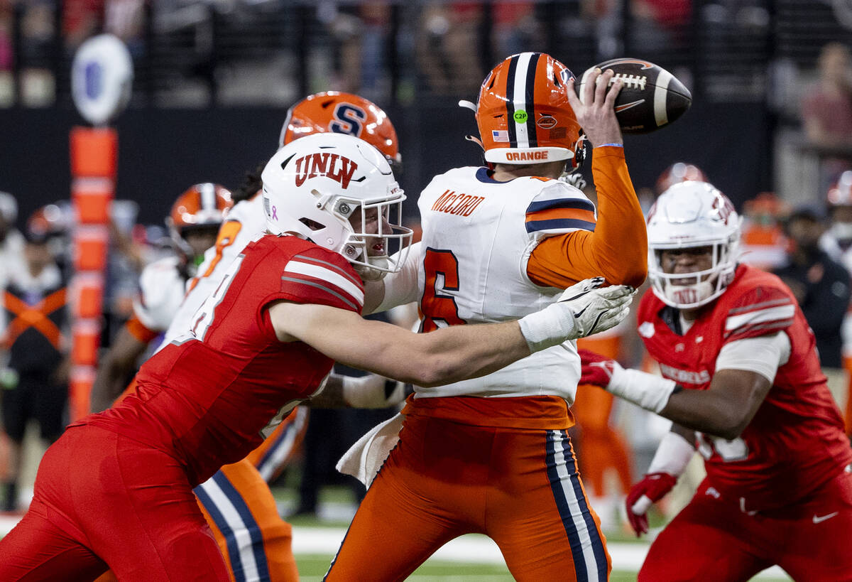 UNLV defensive lineman Fisher Camac (28) disrupts Syracuse Orange quarterback Kyle McCord (6) f ...