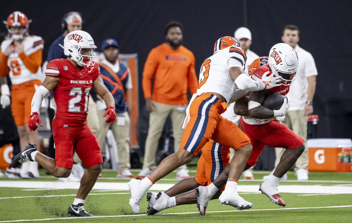 Syracuse Orange defensive back Clarence Lewis (3) tackles UNLV running back Jai'Den Thomas (9) ...