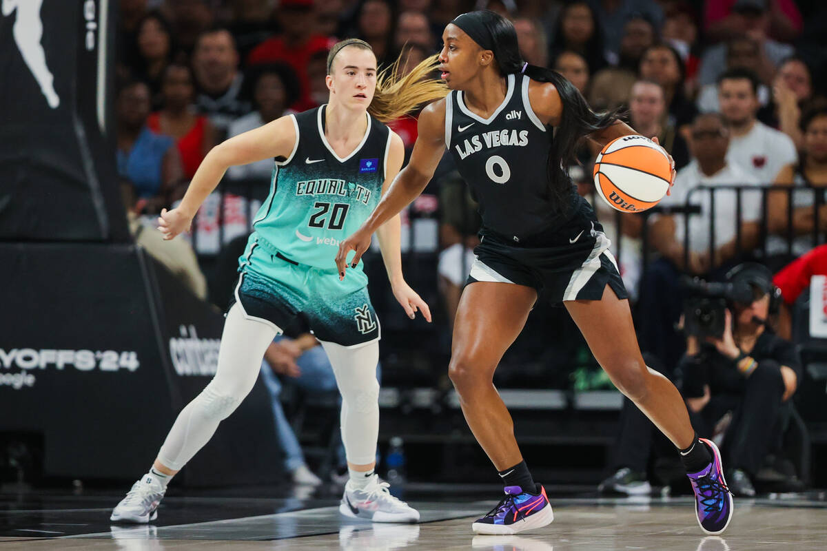 Aces guard Jackie Young (0) moves the ball as New York Liberty guard Sabrina Ionescu (20) guard ...