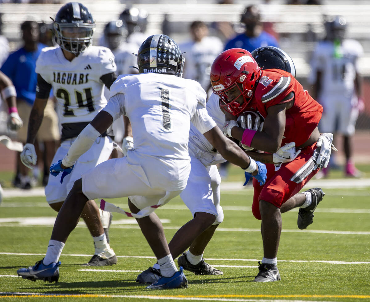 Arbor View running back Sean Moore (2) runs into Desert Pines players during the high school fo ...