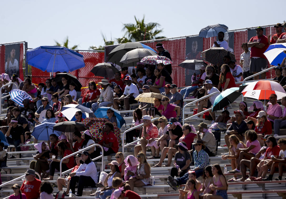 Arbor View fans sit in the stands with umbrellas during the high school football game against D ...