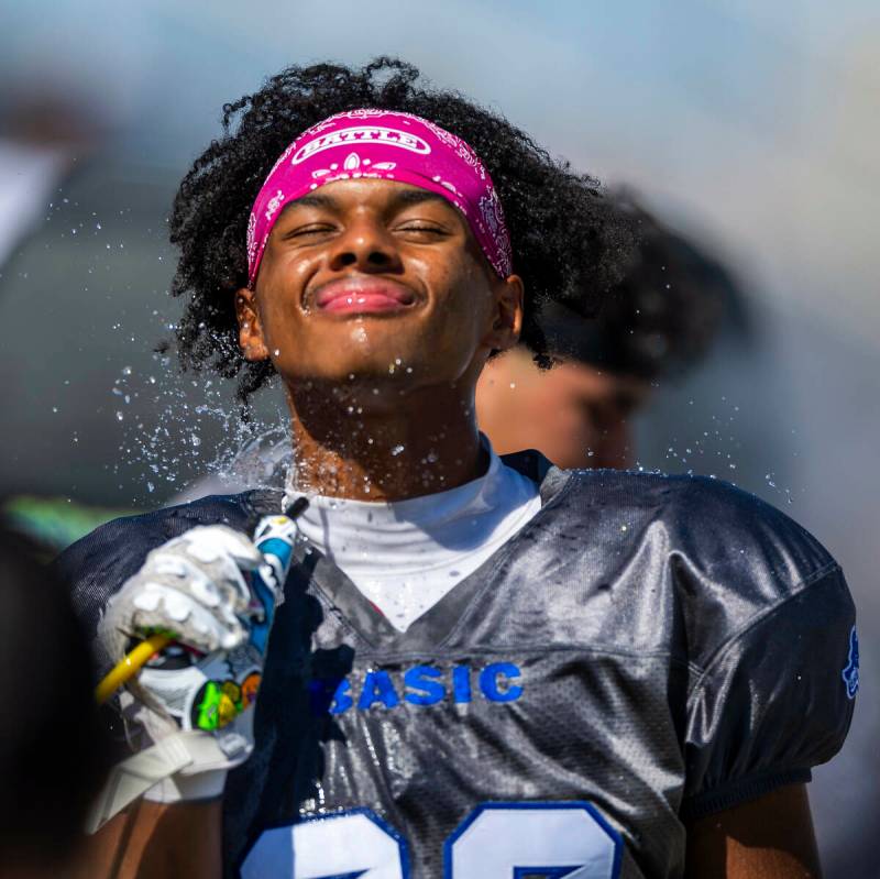 Basic linebacker Lynn Saltmarch (23) cools off from the daytime heat on the sidelines against C ...