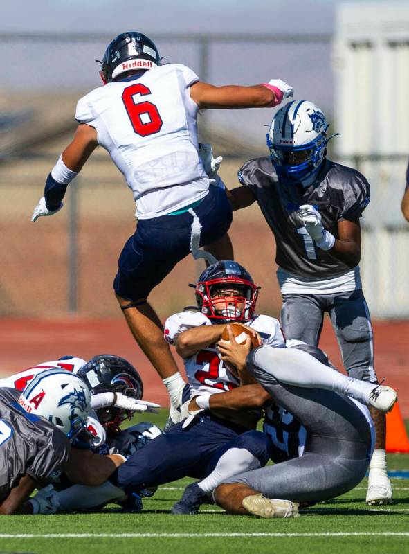 Coronado running back Chance Avila (23) is wrapped up by Basic linebacker Lynn Saltmarch (23) a ...