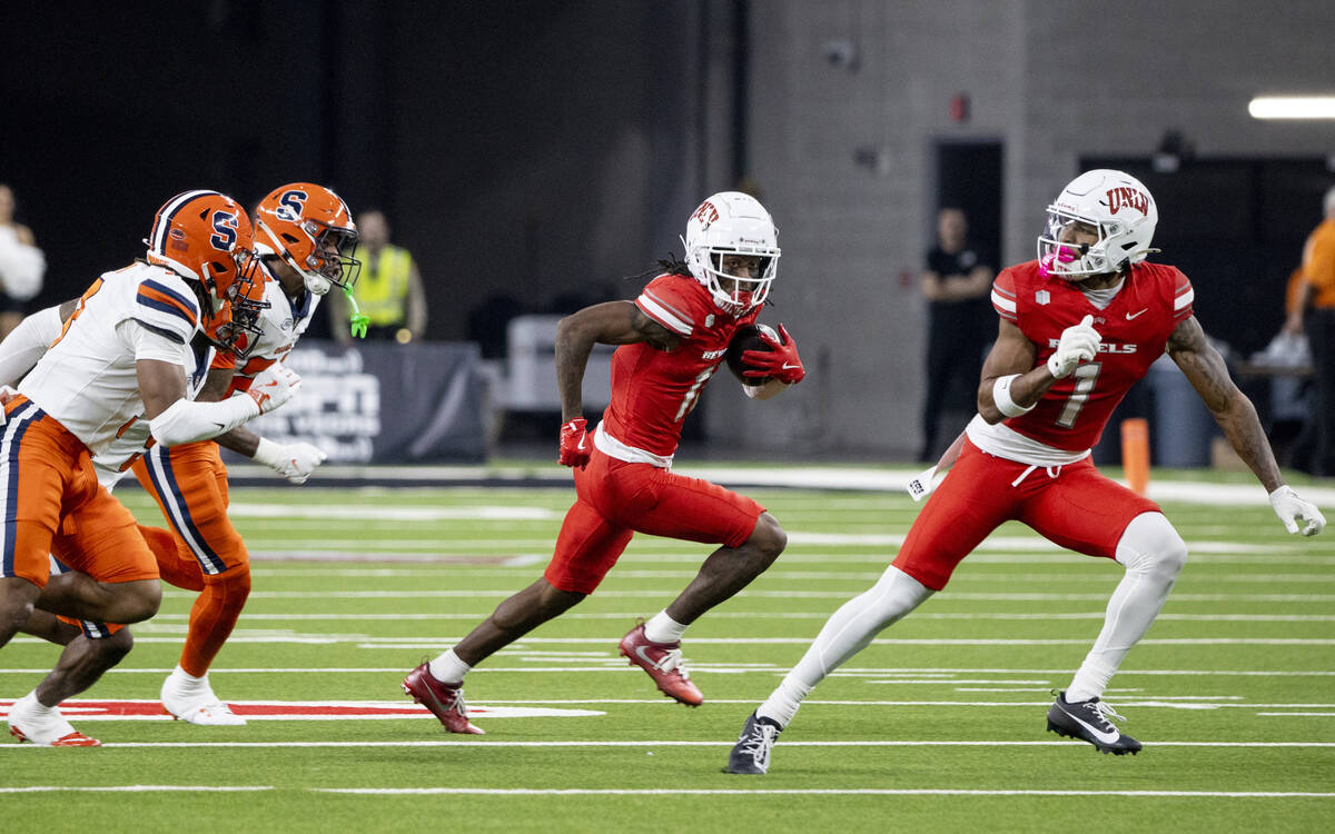 UNLV wide receiver Ricky White III (11) avoids a group of Syracuse Orange defenders during the ...