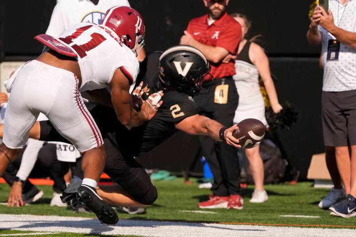 Vanderbilt quarterback Diego Pavia (2) dives for extra yards past Alabama linebacker Jihaad Cam ...