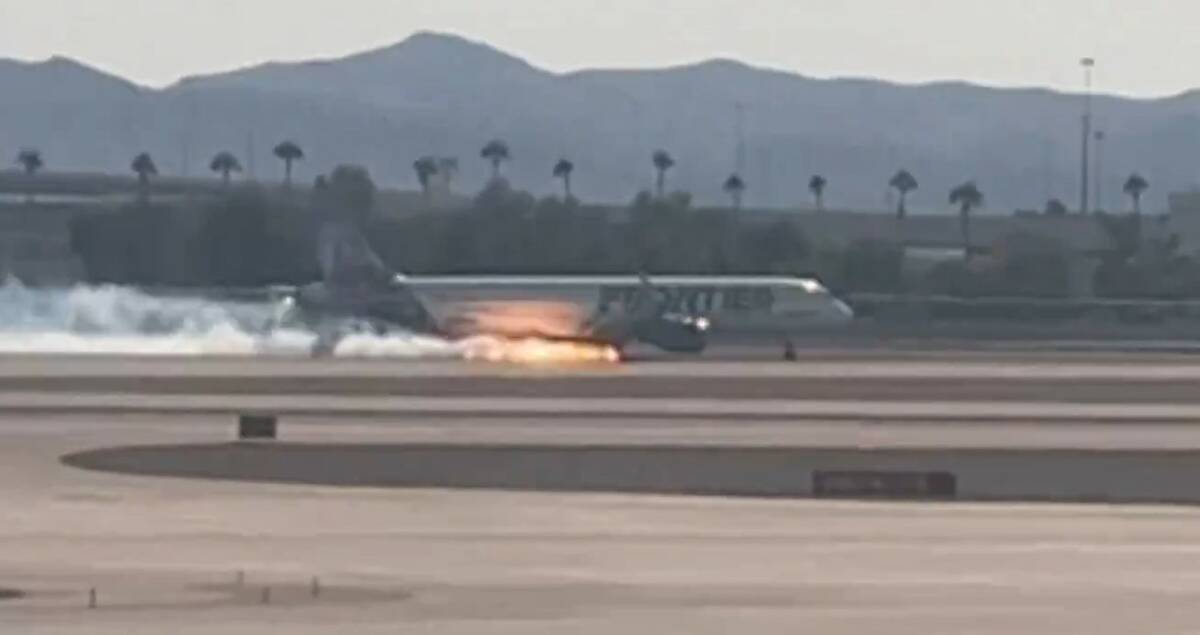 Flames and smoke are seen coming from a Frontier Airlines plane that landed at Harry Reid Inter ...