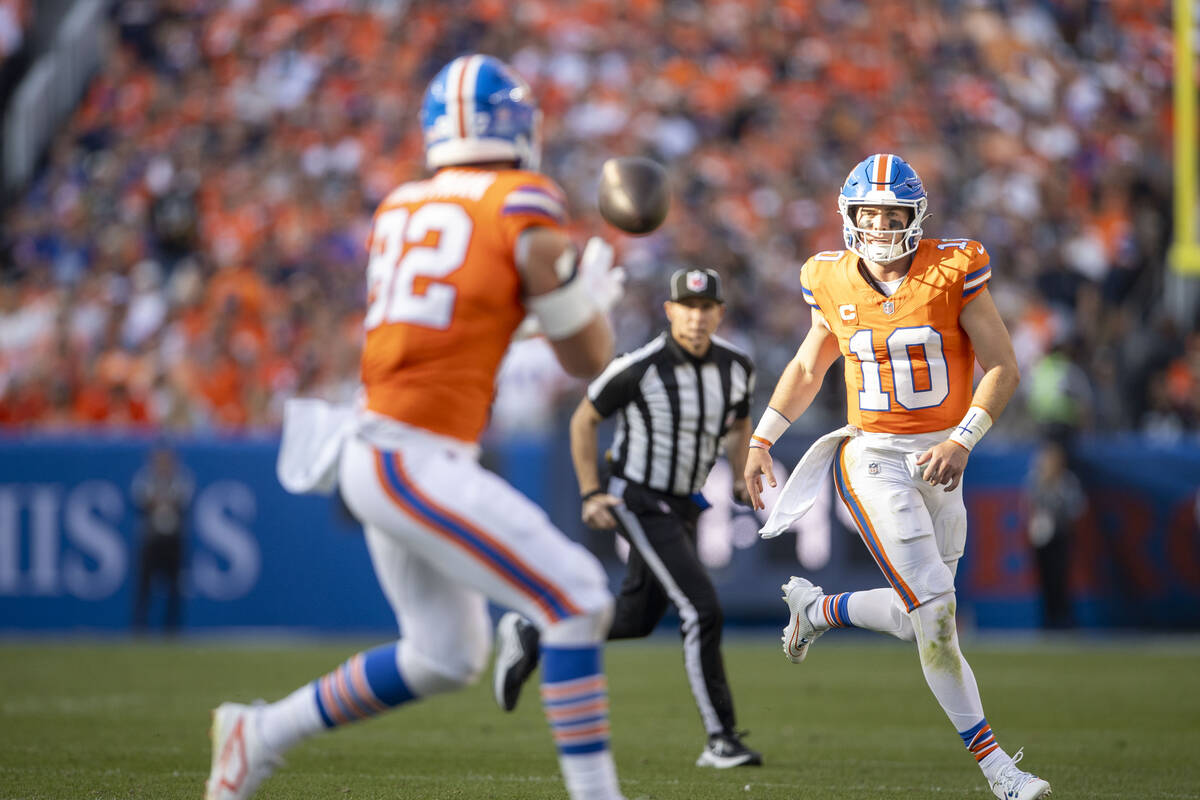 Denver Broncos quarterback Bo Nix (10) passes the football to tight end Adam Trautman (82) duri ...