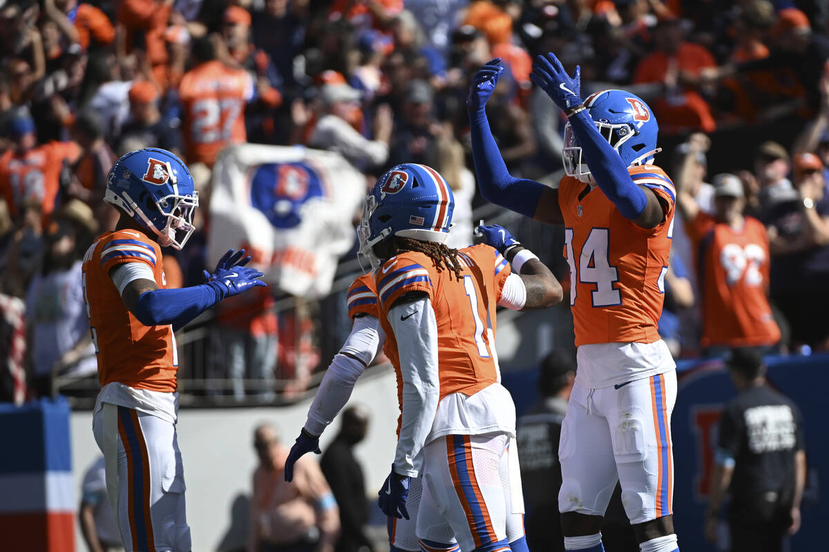 Denver Broncos cornerback Pat Surtain II, left, celebrates his 100-yard interception for a touc ...