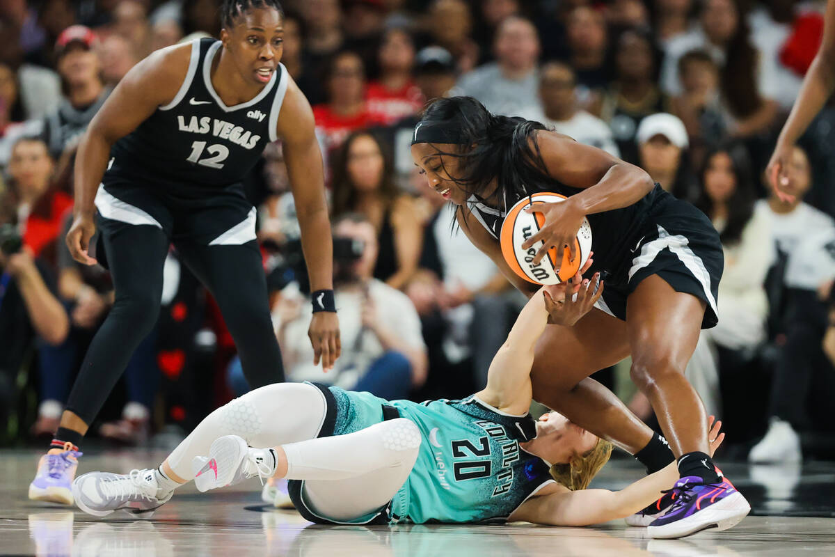 Aces guard Jackie Young (0) gets tangled up with New York Liberty guard Sabrina Ionescu (20) to ...