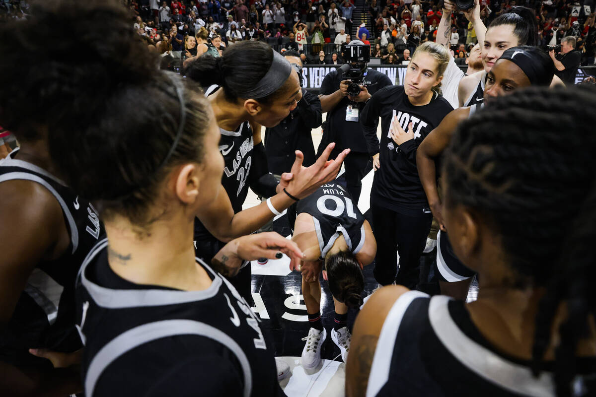 Aces guard Kelsey Plum keeps her head down in the team huddle following a 76-62 loss during gam ...