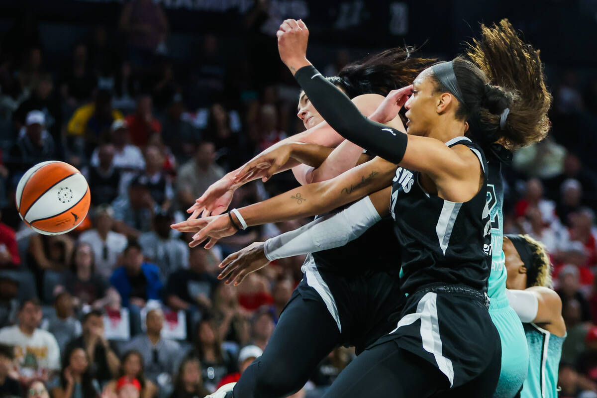 Aces center A'ja Wilson (22) and center Megan Gustafson (17) get tangled up reaching for the ba ...