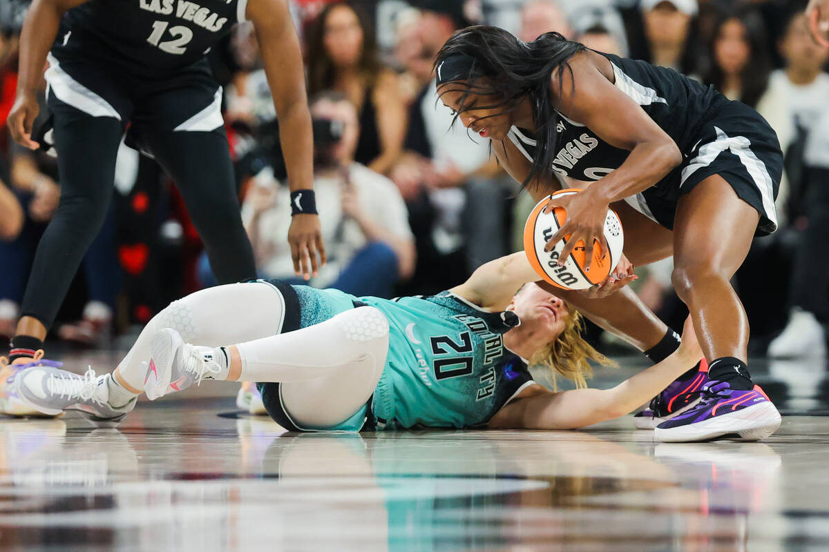 Aces guard Jackie Young (0) gets tangled up with New York Liberty guard Sabrina Ionescu (20) to ...