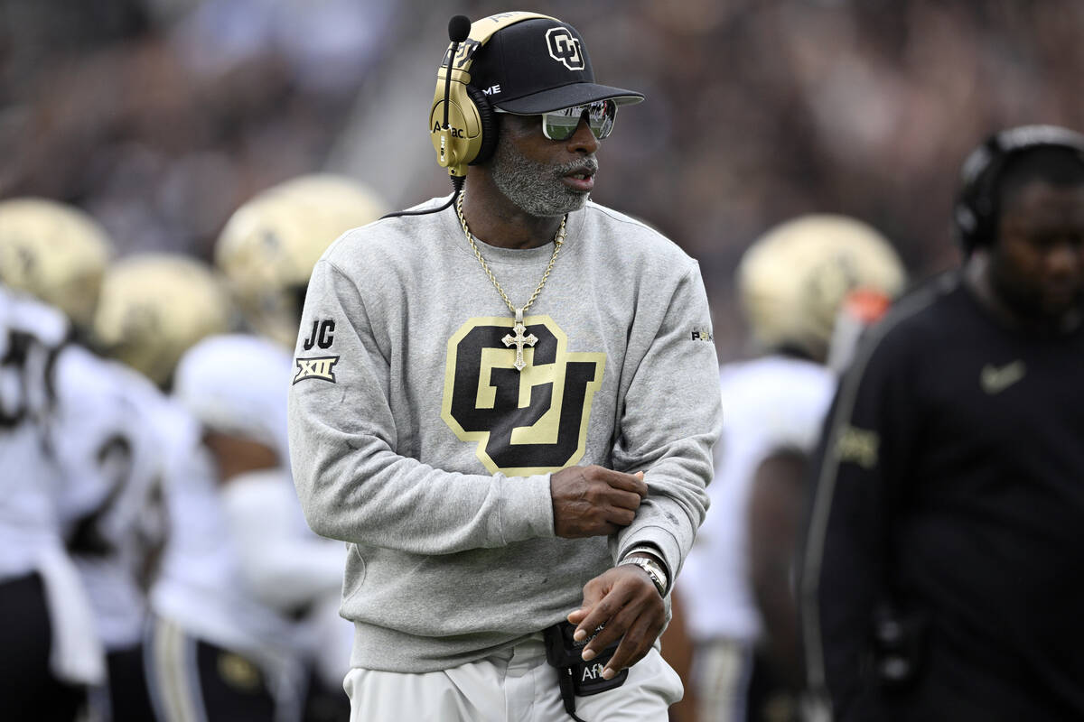 Colorado head coach Deion Sanders walks along the sideline during the first half of an NCAA col ...