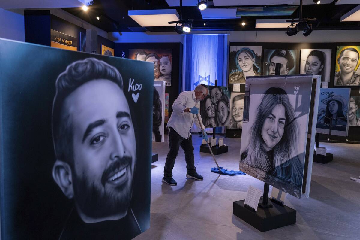 A worker cleans the floor at an exhibition by Israeli graffiti artist Benzi Brofman that displa ...