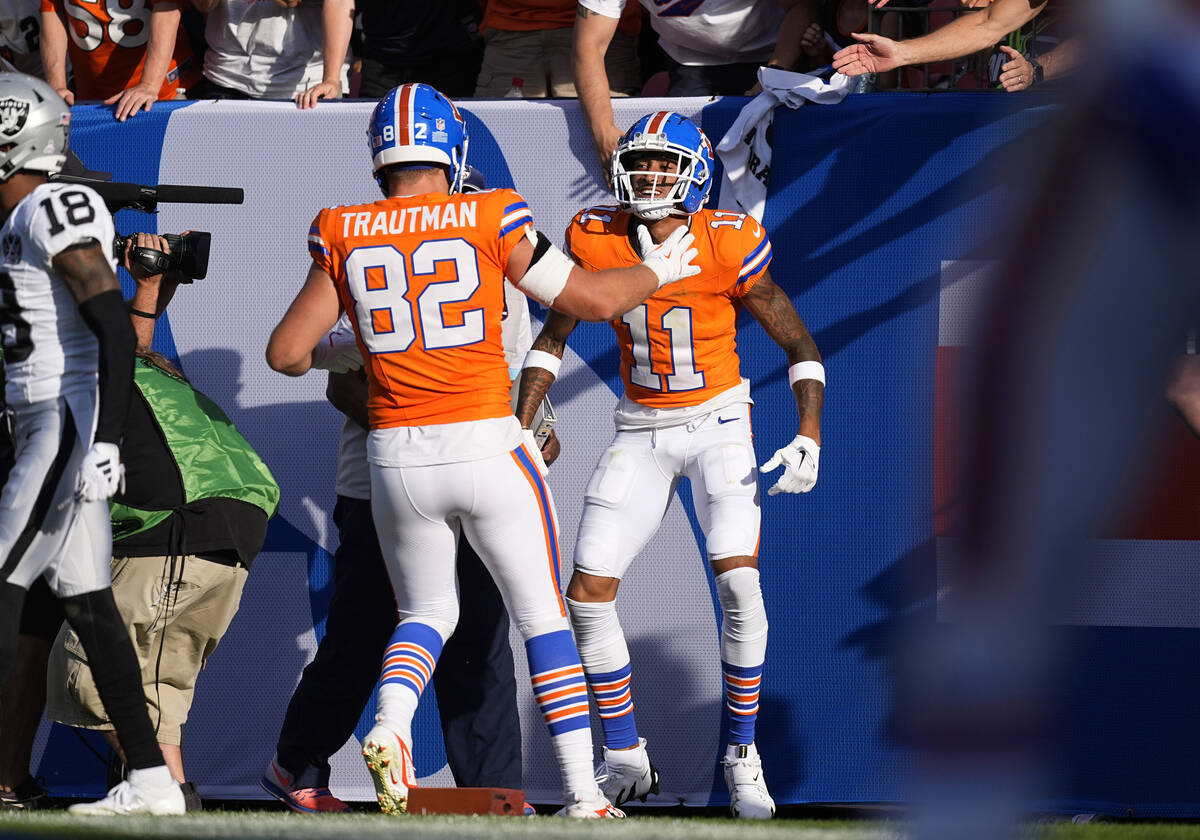 Denver Broncos tight end Adam Trautman, front, congratulates wide receiver Josh Reynolds after ...