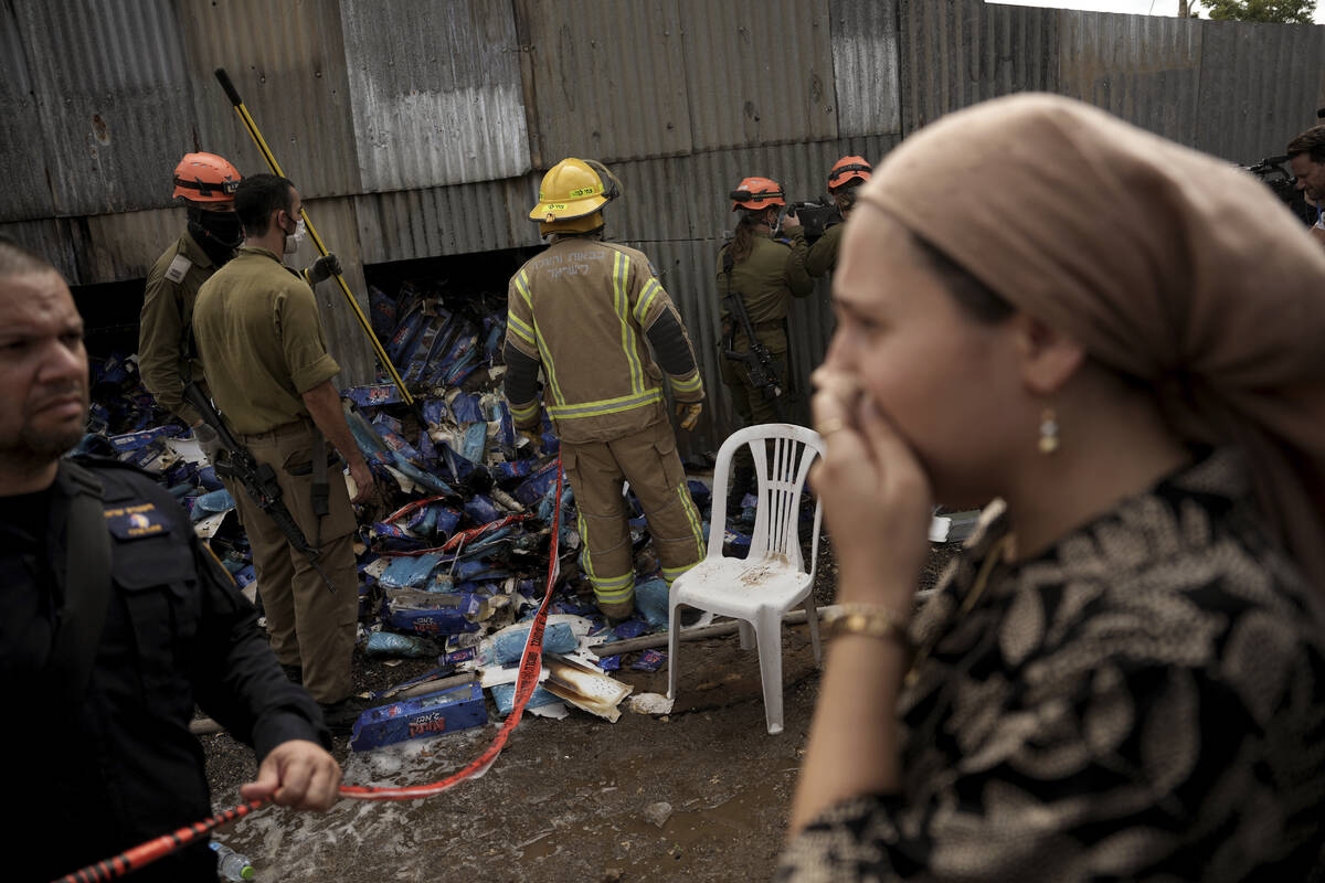 A woman reacts as emergency personnel respond after a rocket apparently fired from Gaza hits Kf ...