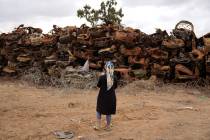 A woman looks at charred vehicles burned in the Oct. 7 cross-border attack by Hamas militants o ...