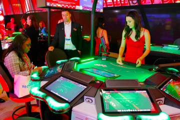 A conventioneer plays on Interblock Gaming's Smart Pit 5-seaters Blackjack table at G2E Las Veg ...