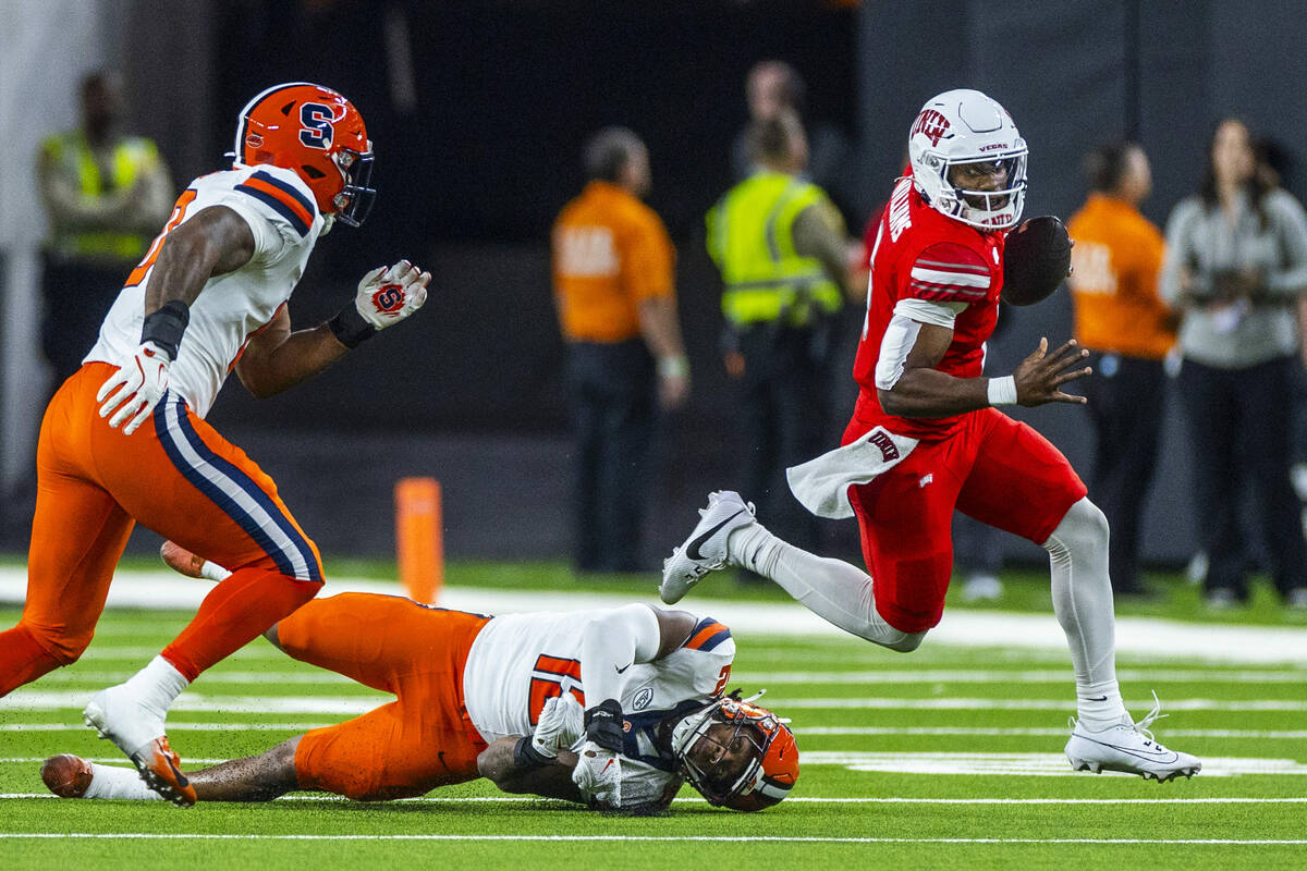 UNLV quarterback Hajj-Malik Williams (6) breaks a tackle attempt by Syracuse Orange linebacker ...