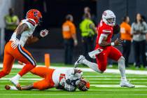 UNLV quarterback Hajj-Malik Williams (6) breaks a tackle attempt by Syracuse Orange linebacker ...