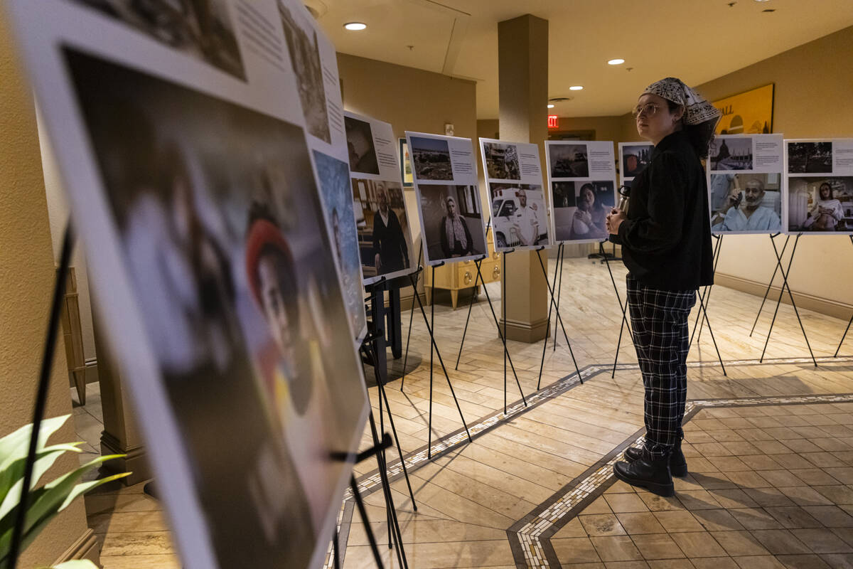 Attendees look through photos of hostages before a ceremony at Midbar Kodesh Temple marking one ...