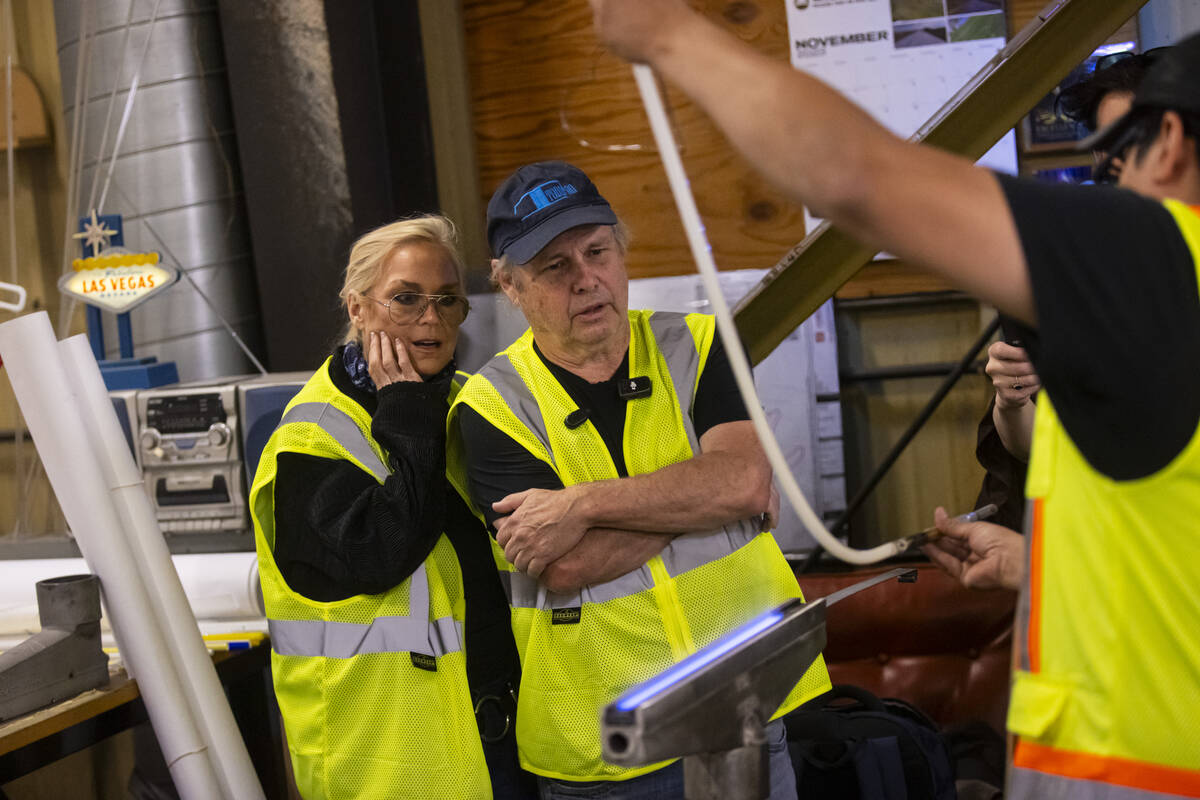 Todd Fisher, second from left, and wife Catherine Hickland get a demonstration from YESCO neon ...