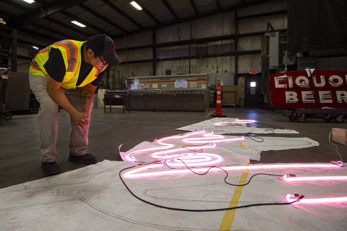 YESCO neon bender Oscar Gonzalez works on placing neon tubes on a diagram for the renovation of ...