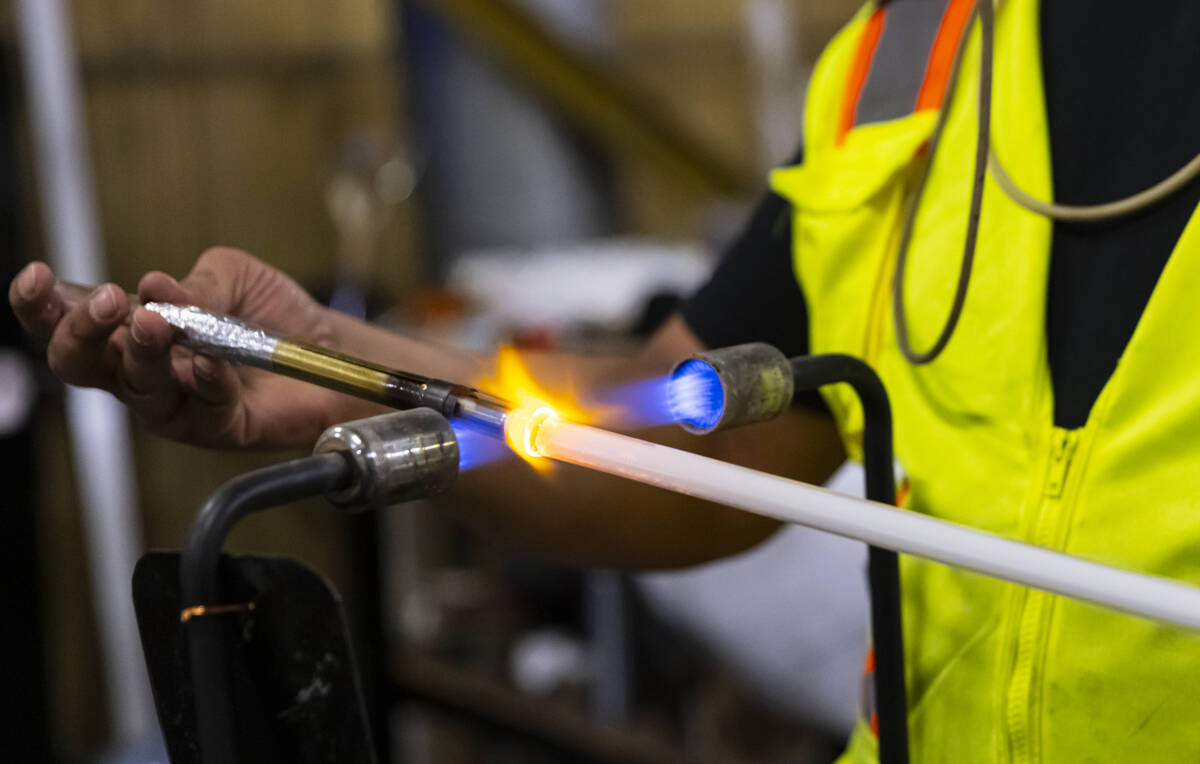 YESCO neon bender Oscar Gonzalez blows glass for a neon tube on Sept. 4 in Las Vegas. (Chase St ...