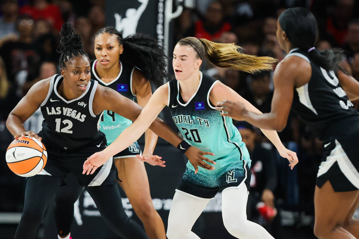 Aces guard Chelsea Gray (12) keeps New York Liberty guard Sabrina Ionescu (20) at bay as she dr ...