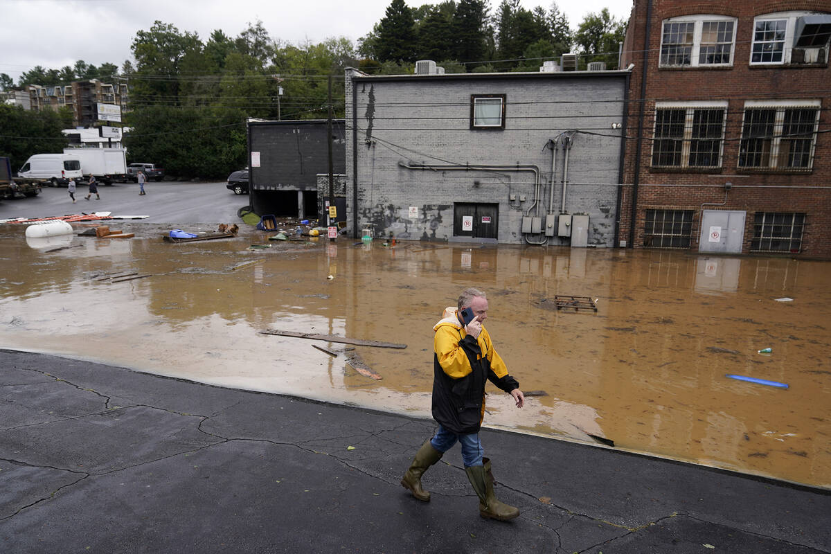 FILE - A man walks near a flooded area near the Swannanoa river, effects from Hurricane Helene ...